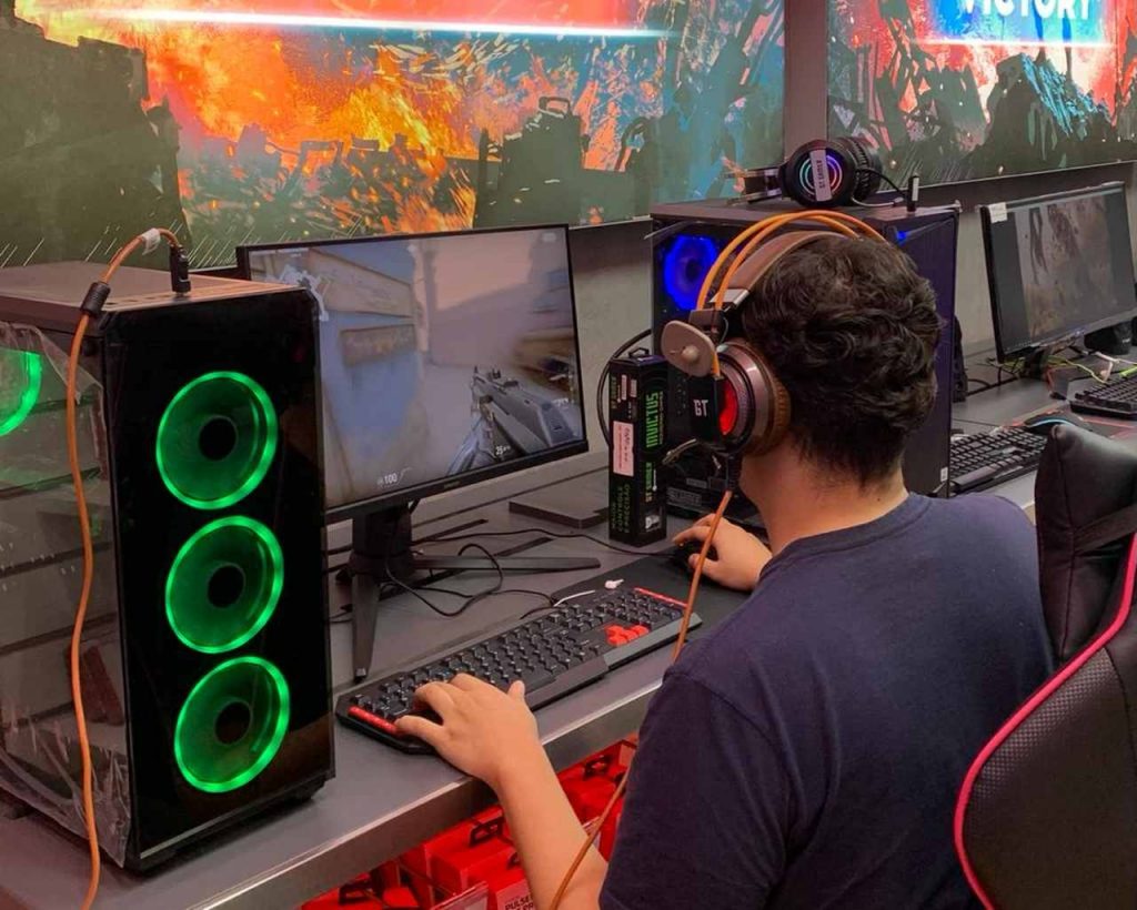 Homem em uma bancada jogando em seu PC Gamer