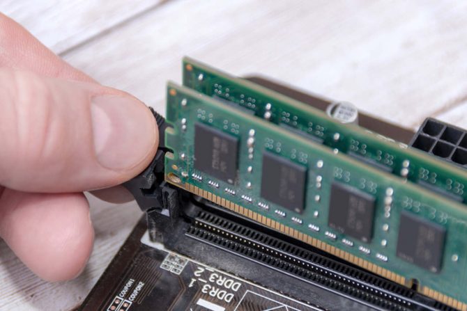 Pessoa mexendo em uma memÃ³ria RAM de computador gamer
