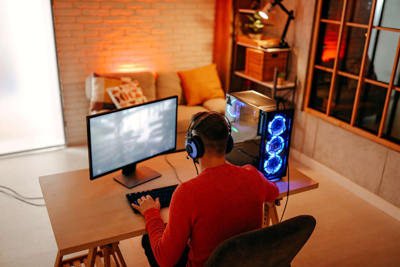 Homem em casa jogando com o seu PC gamer