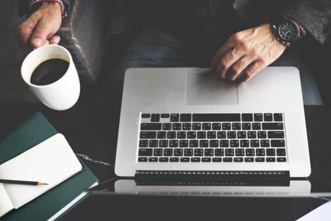 Homem trabalhando com o notebook em cima da mesa
