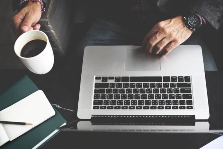 Homem trabalhando com o notebook em cima da mesa